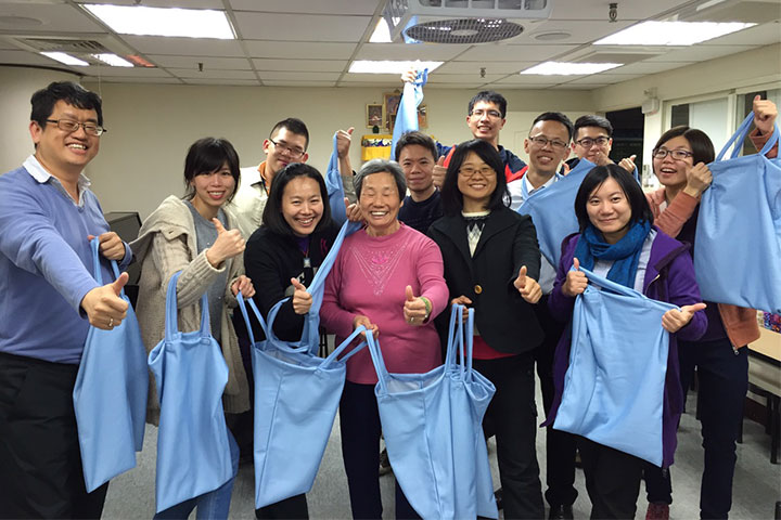 響應淨塑護生的理念，72歲的李秀霞（中間穿粉紅衣者）在一週內縫製了50個環保袋，希望能與其他人結善緣、共造善業。