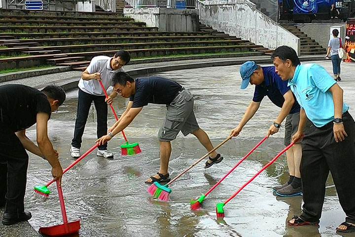為了讓觀眾有最好的體驗，一群夢蓮花讚頌團的男性團員，趁著彩排的空檔，整理因颱風來襲、大雨積水的演出場地。