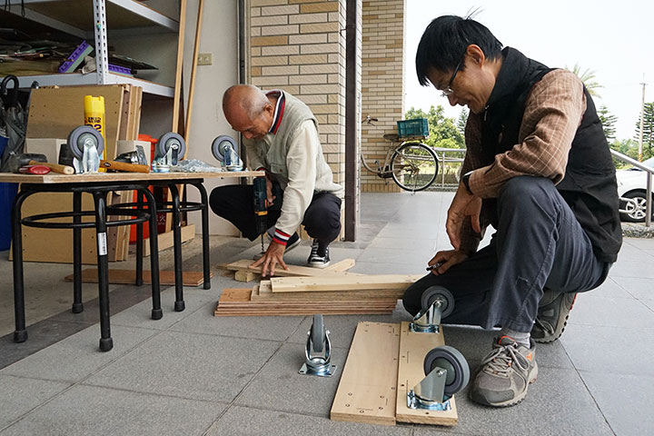 湯敬忠與陳俊宏於福智教育園區認真做木工的身影