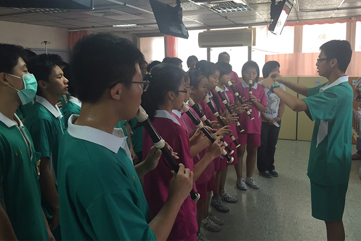 學生們專注地吹著直笛，努力將愛傳遞出去。
