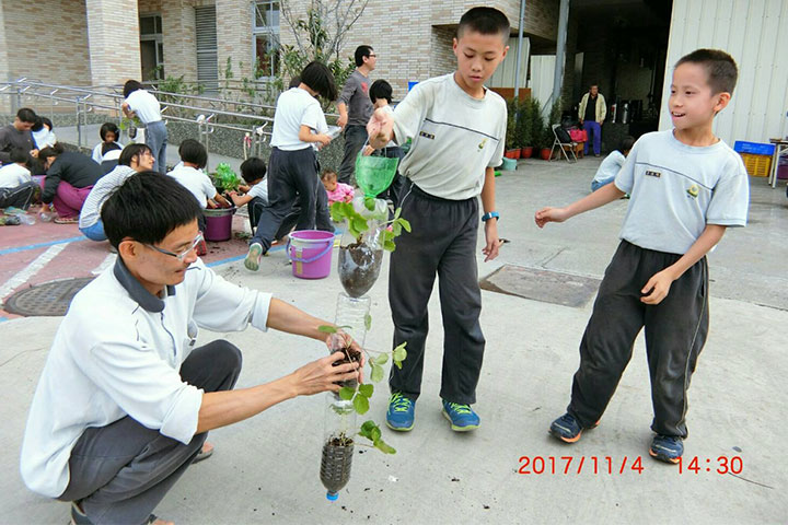 福智國小五年孝班的孩子們，正依著老師教導的步驟，合力完成寶特瓶植株。